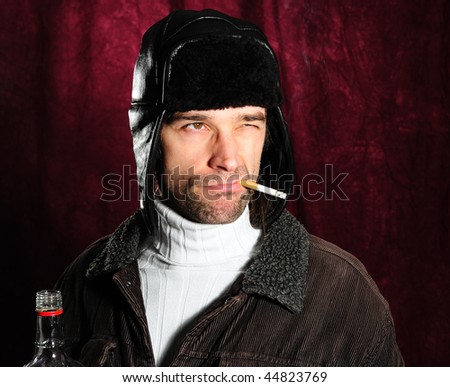 young man with cigarette, bottle and coat cap