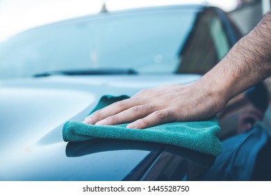 young man cleaning car in street - Shutterstock ID 1445528750