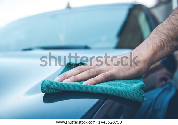 young man cleaning car in
street