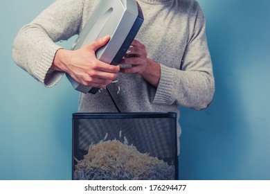 Young Man Is Cleaning Paper From A Shredder