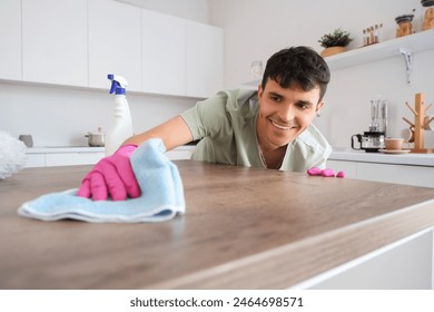 Young man cleaning table in kitchen - Powered by Shutterstock