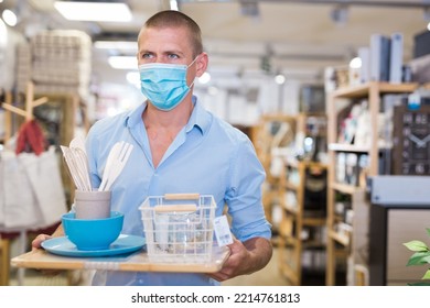 Young Man Client Buyer In Face Mask Choosing Variety Accessories And Tableware In Modern Shop For Decor