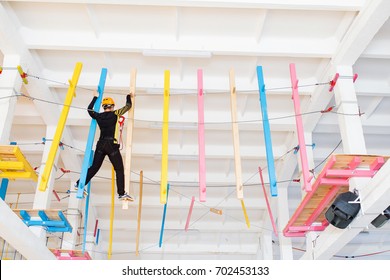 Young man climb with rope belay and helmet at indoors amusement rope park - Powered by Shutterstock