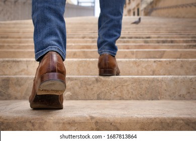 A young man climbing up along large endless stair alone