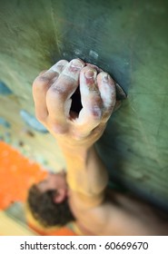 Young Man Climbing On Indoor Wall