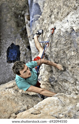 Similar – Rock climber clinging to a cliff.