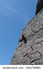 Young Man Climbing On Via Ferrata Himmelstigen, Trolltunga Way Norway