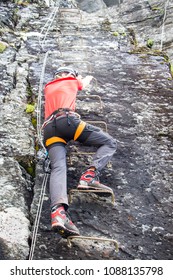 Young Man Climbing On Via Ferrata Himmelstigen, Trolltunga Way Norway