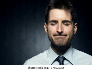 Young Man With Closed Eyes Focused On Thinking.