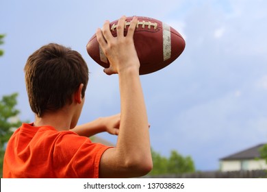 A young man cocking his arm back and getting ready to throw a football