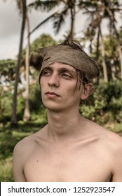 Young Man In Coconut Headband In The Jungle. Shipwreck Survivor.