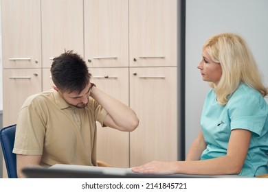 Young Man Complaining On Headache To Practitioner