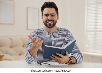 Young Man Conducting Webinar At Desk In Room