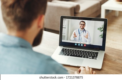 A Young Man Conducts A Video Conference Video Chat Consultation With A Doctor Online Sitting At Home
