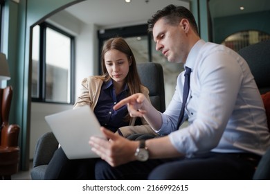 Young Man Consulting His Business Partner At Meeting In Office