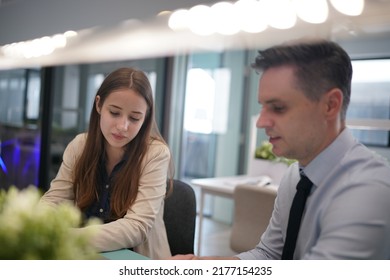 Young Man Consulting His Business Partner At Meeting In Office