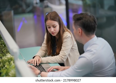 Young Man Consulting His Business Partner At Meeting In Office