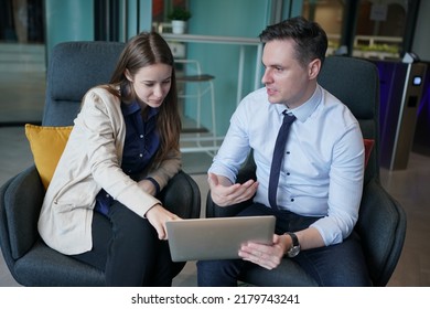 Young Man Consulting His Business Partner At Meeting In Office