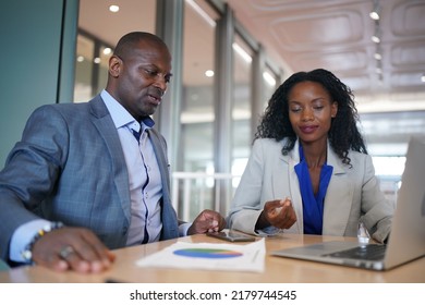 Young Man Consulting His Business Partner At Meeting In Office