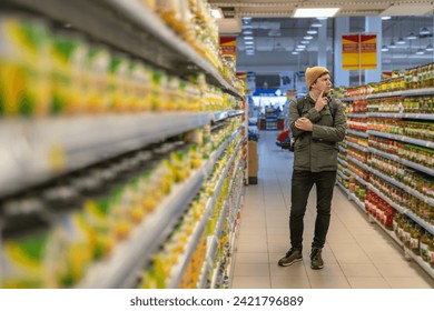 Young Man Contemplating Choices in Grocery Store Aisle - Powered by Shutterstock