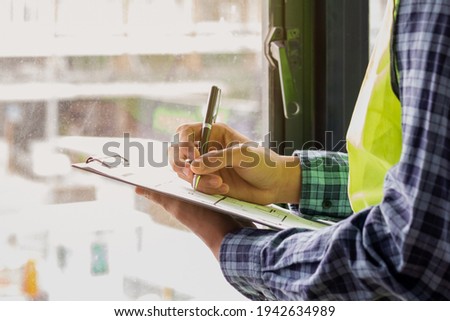 Young man contractor, engineering or employee holding, clipboard, looking at paperwork on the inspecting the reconstructed construction and renovation after to check defect of apartment,home at site. Foto d'archivio © 