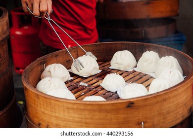 Young Man Cooking Chinese Traditional Steamed Buns At The Street Food Stall In Chinatown, Kuala Lumpur, Malaysia.