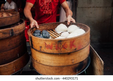 Young Man Cooking Chinese Traditional Steamed Buns At The Street Food Stall In Chinatown, Kuala Lumpur, Malaysia.