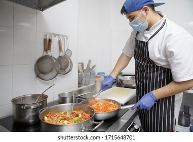 Young Man Cooking Food For Delivery In Mask And Gloves, Quarantine Take Away Food