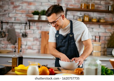 Young Man Cooking In The Kitchen. Home Chef Preparing A Great Meal.