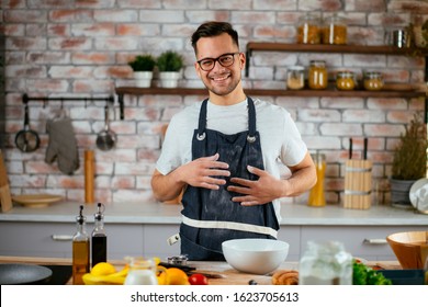 Young Man Cooking In The Kitchen. Home Chef Preparing A Great Meal.