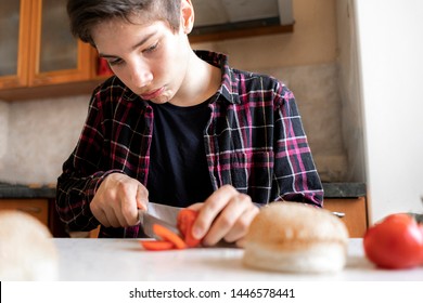 Young Man Cooking Make Hamburger At Home On The Table