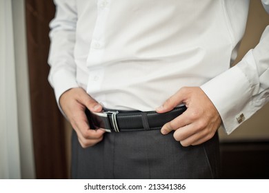 The Young Man Corrects A Belt On Trousers.