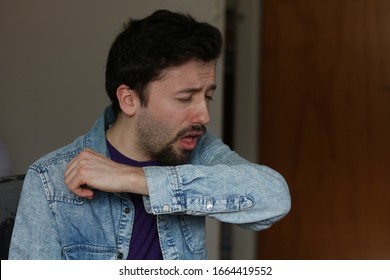 Young Man Coughing into his Elbow. Sick due Coronavirus concept. Prevention Measures Preventing COVID -19 Spread.  - Shutterstock ID 1664419552