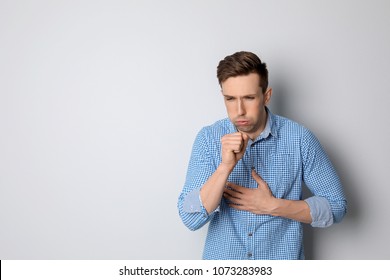 Young Man Coughing On Light Background