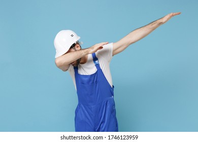Young man in coveralls protective helmet hardhat isolated on pastel blue background in studio. Instruments accessories for renovation apartment room. Repair home concept. Showing DAB dance gesture - Shutterstock ID 1746123959