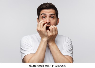 Young man covering mouth with hands and round eyes, wearing round eyeglasses, experiencing astonishment and fear, isolated on gray background - Shutterstock ID 1462800623