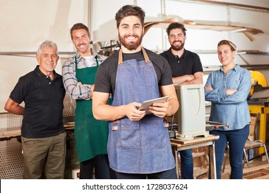 Young man as a craftsman apprentice using tablet computer in his joiner's shop - Powered by Shutterstock