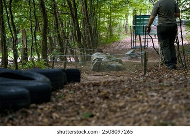 young man crawling on the ground under obstacle during endurance test assessed by scorer  - Powered by Shutterstock