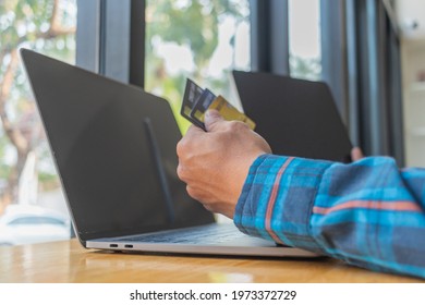 A Young Man With A Credit Card In His Hand, Sitting In Agitation In Front Of A Computer When He Sees A Debt Collection Document From The Credit Card Company For Unable To Pay The Credit Card Debt.