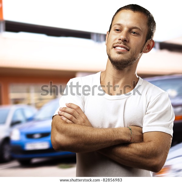 young man with\
crossed arms in the\
street