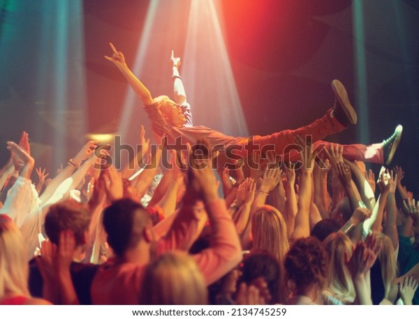 A young man crowd surfing to his favorite band.\
This concert was created for the sole purpose of this photo shoot,\
featuring 300 models and 3 live bands. All people in this shoot are\
model released.