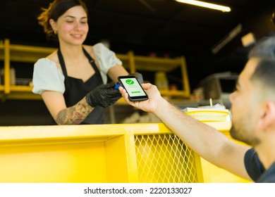 Young man customer paying his lunch to the stall vendor after eating street food  - Powered by Shutterstock