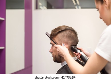  young man cuts hair in the beautiful barber shop - Powered by Shutterstock