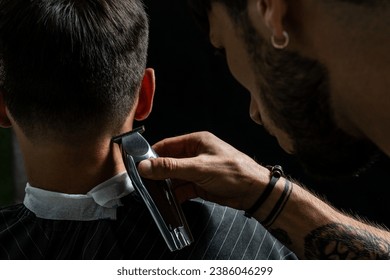 Young man cutting hair at barbershop, barber at work, trimmer - Powered by Shutterstock