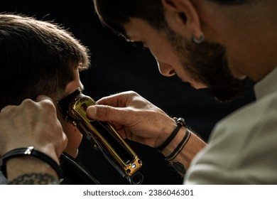 Young man cutting hair at barbershop, barber at work, trimmer - Powered by Shutterstock