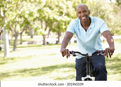 Young  man cycling in park - Shutterstock ID 201965539