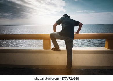The young man is deciding to commit suicide by jumping off a bridge.