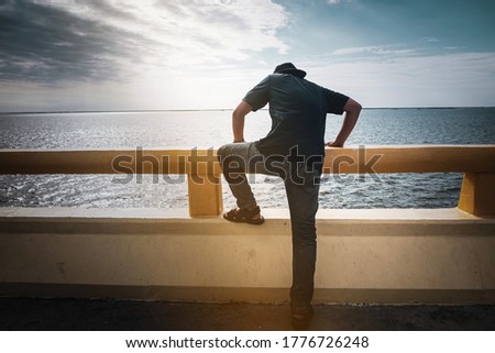 The young man is deciding to commit suicide by jumping off a bridge.