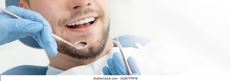 Young Man At The Dentist. Dental Care, Taking Care Of Teeth. Picture With Copy Space For Background.