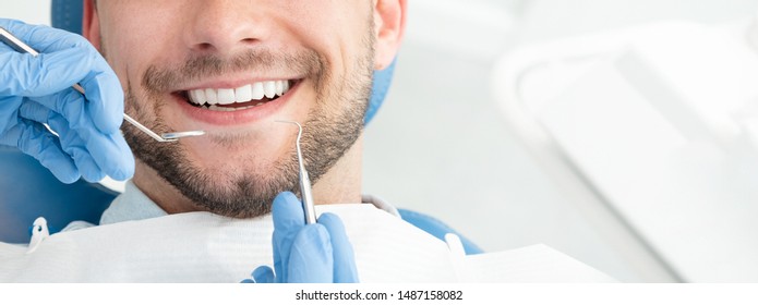 Young man at the dentist. Dental care, taking care of teeth. Picture with copy space for background. - Shutterstock ID 1487158082